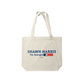 Natural canvas tote bag with navy text and a small red and blue flag design.